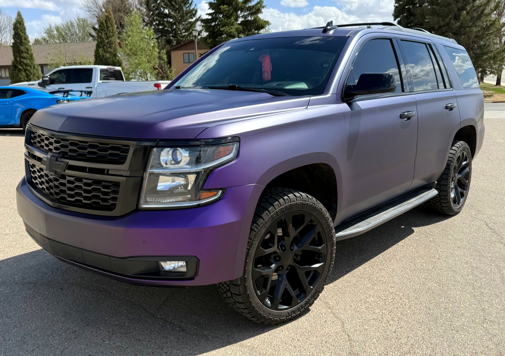 Purple color-shift wrapped Chevrolet Tahoe with black wheels outdoors