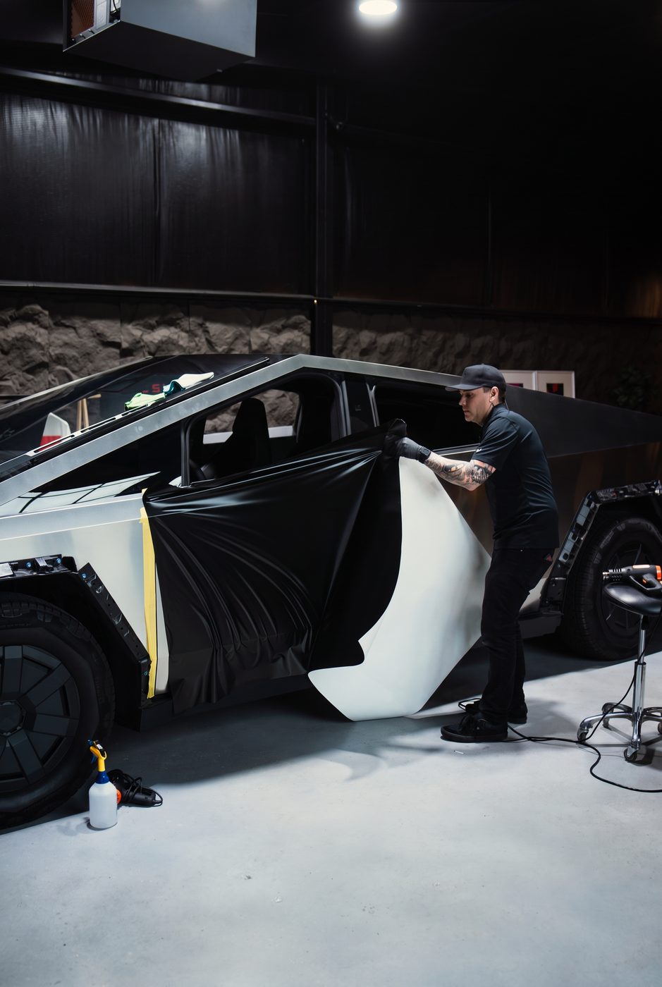Vinyl wrap film being laid over a Cybertruck door during a full color change at High Society Customs