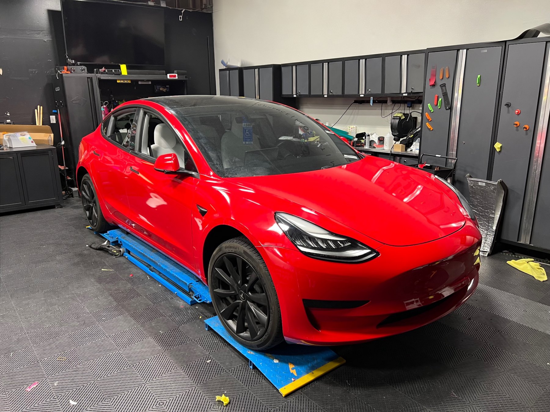 Gloss red wrapped Tesla Model 3 in the workshop